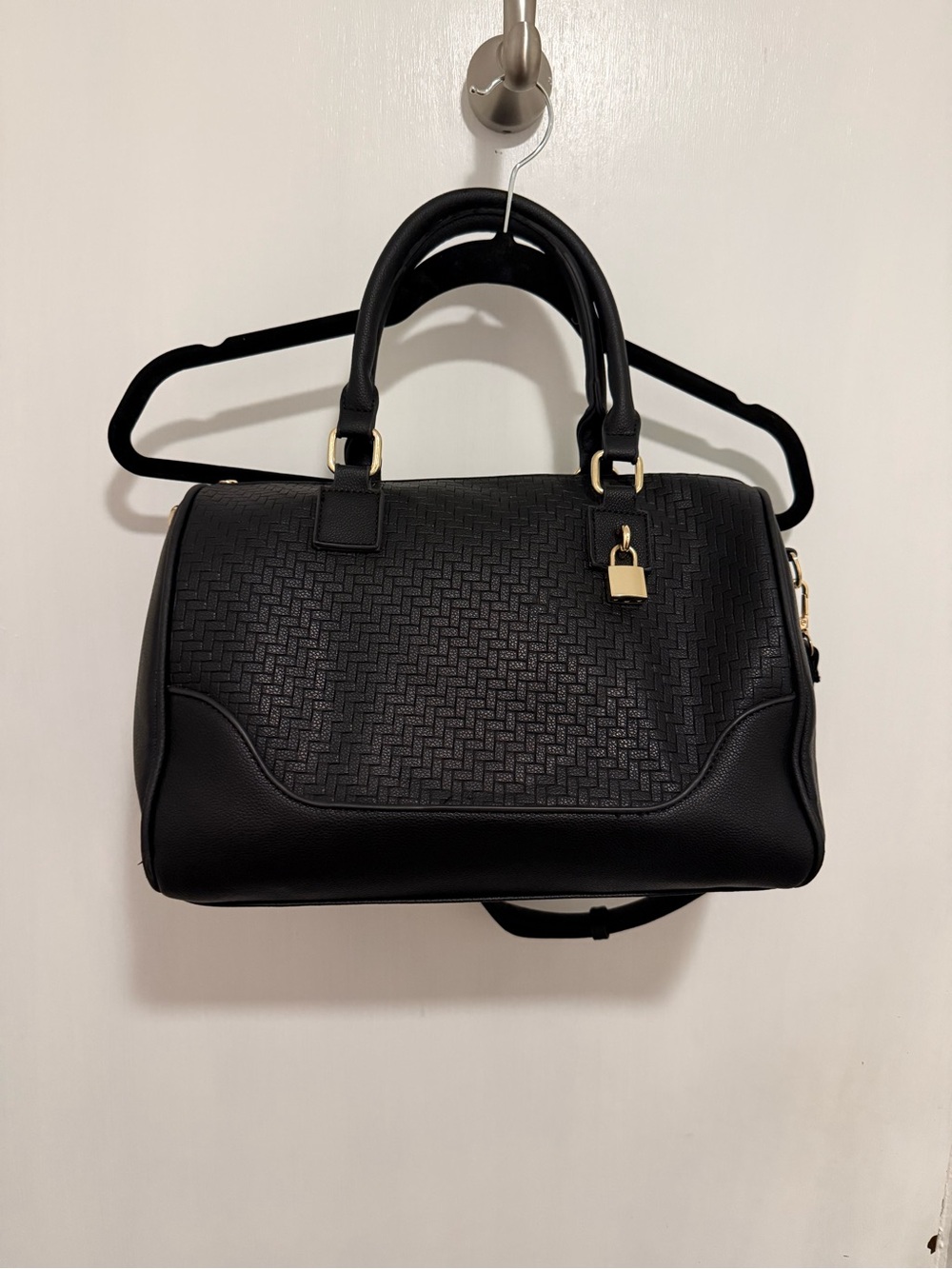 black woven duffle bag with gold hardware, some wear in the handles, no brand.